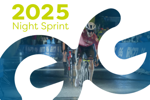 Racing cyclist races across the finish line in the rainy pedestrian zone of St. Anton, cheering - with a clenched fist - in front of many spectators. ‘2025 Night Sprint’ is written in yellow/green at the top left of the picture.