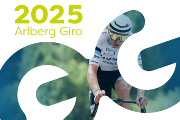 Rennradfahrer im Fokus konzentriert am Fahren, im Hintergrund sind grüne, üppige Wälder zu sehen. "2025 Arlberg Giro" ist am Bild oben links in gelb/grün geschrieben. 