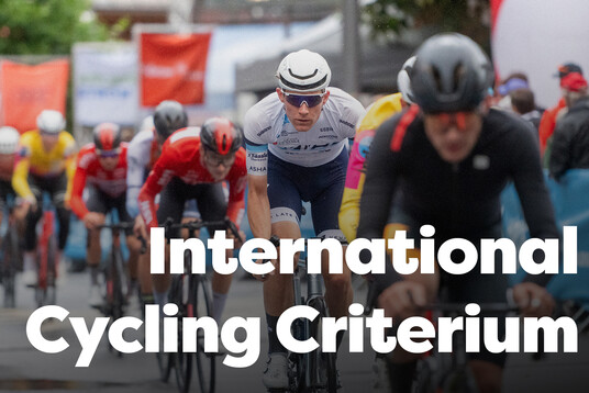 Professional cyclists ride quickly through the rainy village centre of St. Anton am Arlberg