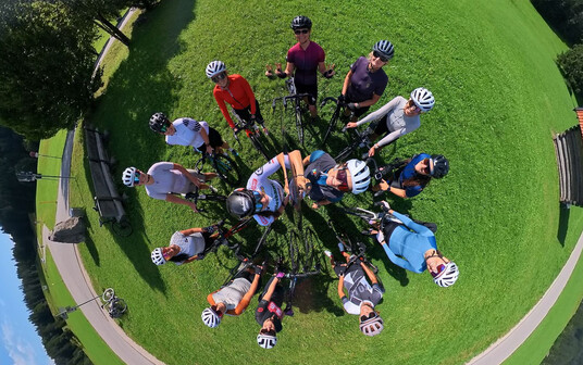 Weitwinkelaufnahme einer Radgruppe auf einer grünen Wiese