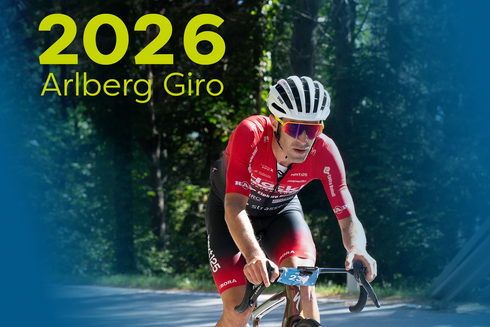 Fahrradfahrer in roter kleidung beim Arlberg Giro. "2026 Arlberg Giro" ist am Bild oben links in gelb/grün geschrieben. 