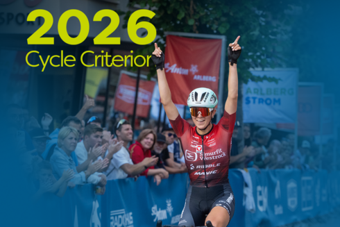 Athlete crossing the finish line. ‘2026 Professional Criterium’ is written in yellow and green in the top left-hand corner of the image.