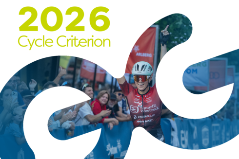 Athlete crossing the finish line. ‘2026 Professional Criterium’ is written in yellow and green in the top left-hand corner of the image.